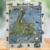 A Newfoundland and Smidge of Labrador wooden puzzle with whimsy pieces displayed on a wooden surface against a blurred green background.