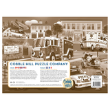 Cobble Hill puzzle tray with police car, fire truck, and ambulance illustration.