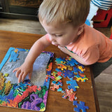 Child playing with a colorful puzzle on a wooden table