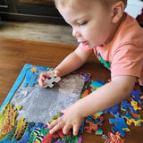 Child playing with a puzzle on a wooden table
