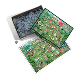 A completed jigsaw puzzle, its green box, and an open box filled with puzzle pieces on a white background. The puzzle features a whimsical, detailed illustration of a busy outdoor market or fair scene with people, animals, and stalls.