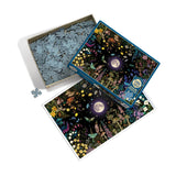 Jigsaw puzzle set with a fantasy design featuring a moon and nature elements, partially completed.