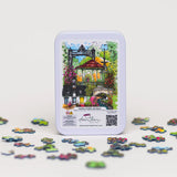 Jigsaw puzzle set with a tin featuring a colorful illustration of a gazebo and surrounding garden on a white background.