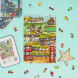Jigsaw puzzle with pieces scattered on a light blue background, featuring a colorful illustration of a town.