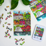 Colorful puzzle with completed pieces and packaging on a white surface