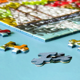 Colorful puzzle pieces on a blue surface with a partially completed puzzle.