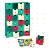 A 24-door advent calendar with colorful numbered drawers, shown open with a completed jigsaw puzzle and a few loose pieces on a white background with subtle gold star accents.