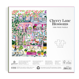 Cherry Lane Blossoms puzzle packaging with colorful illustration of a street scene.
