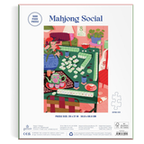 Back of a Mahjong Social jigsaw puzzle box showing a colorful illustrated scene of a mahjong game table with tiles, flowers, and furniture. The box is white with blue title text and product details printed along the bottom.