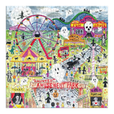 A completed jigsaw puzzle featuring a colorful, whimsical Halloween amusement park scene with a Ferris wheel, carousel, haunted house, ghosts, pumpkins, and playful figures on a grassy background.