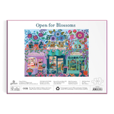 Puzzle box with a colorful illustration of a quaint town street and 'Open for Blossoms' text.
