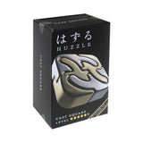Huzzle puzzle packaging with black box and silver and gold puzzle piece design.
