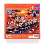 Back of a jigsaw puzzle box featuring a detailed illustrated scene of a cruise ship sailing on the Nile with pyramids and desert landscapes, plus text and product details on an orange border.