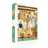 A boxed jigsaw puzzle from Puzzle Company titled "Saturday Pancakes," shown at a slight angle on a clean white background. The front and spine display the illustrated scene of a cozy kitchen with people preparing pancakes, plus green side panels with product text including "New York," "Jigsaw Puzzle," and "300 pieces.