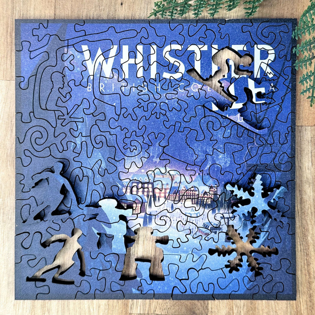 Wooden puzzle with cut-out shapes on a blue background, featuring the word 'Whistler'.
