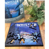 Whistler British Columbia puzzle on a wooden surface with a cap and plants in the background
