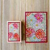 A  floral-patterned minipuzzle on a wooden surface, along with a puzzle box.