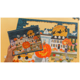 Halloween-themed puzzle with a completed section and a hand holding a piece.