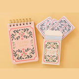 Set of playing cards with decorative cover on a yellow background along with a matching score pad