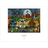 A framed art print featuring a colorful, whimsical illustration of a spooky Halloween street scene under a full moon. The print includes multiple haunted houses, a witch flying on a broomstick, ghosts, and a dark stormy sky.