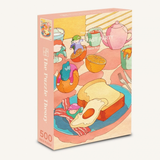 A 500-piece jigsaw puzzle box titled 'The Breakfast  Party' with a whimsical retro illustration of a breakfast table featuring toast, an egg, bacon, cups, and a teapot in pastel colors.