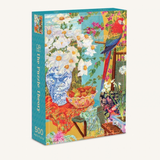 A 500-piece jigsaw puzzle box titled 'Courtyard Haven' featuring a colorful, detailed illustration of a still life scene with white flowers, a blue-and-white vase, fruit, and a red-and-blue parrot, shown on a light cream background.
