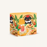 A square decorative puzzle box with a whimsical illustration of clown characters, cupcakes, green leaves, and a yellow-orange table setting on a plain light background.