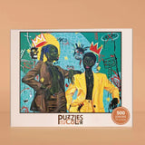 Puzzles of Color packaging with two stylized figures and colorful design elements on a beige background