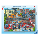 Ravensburger puzzle packaging with fire trucks and firefighters on a city street scene.