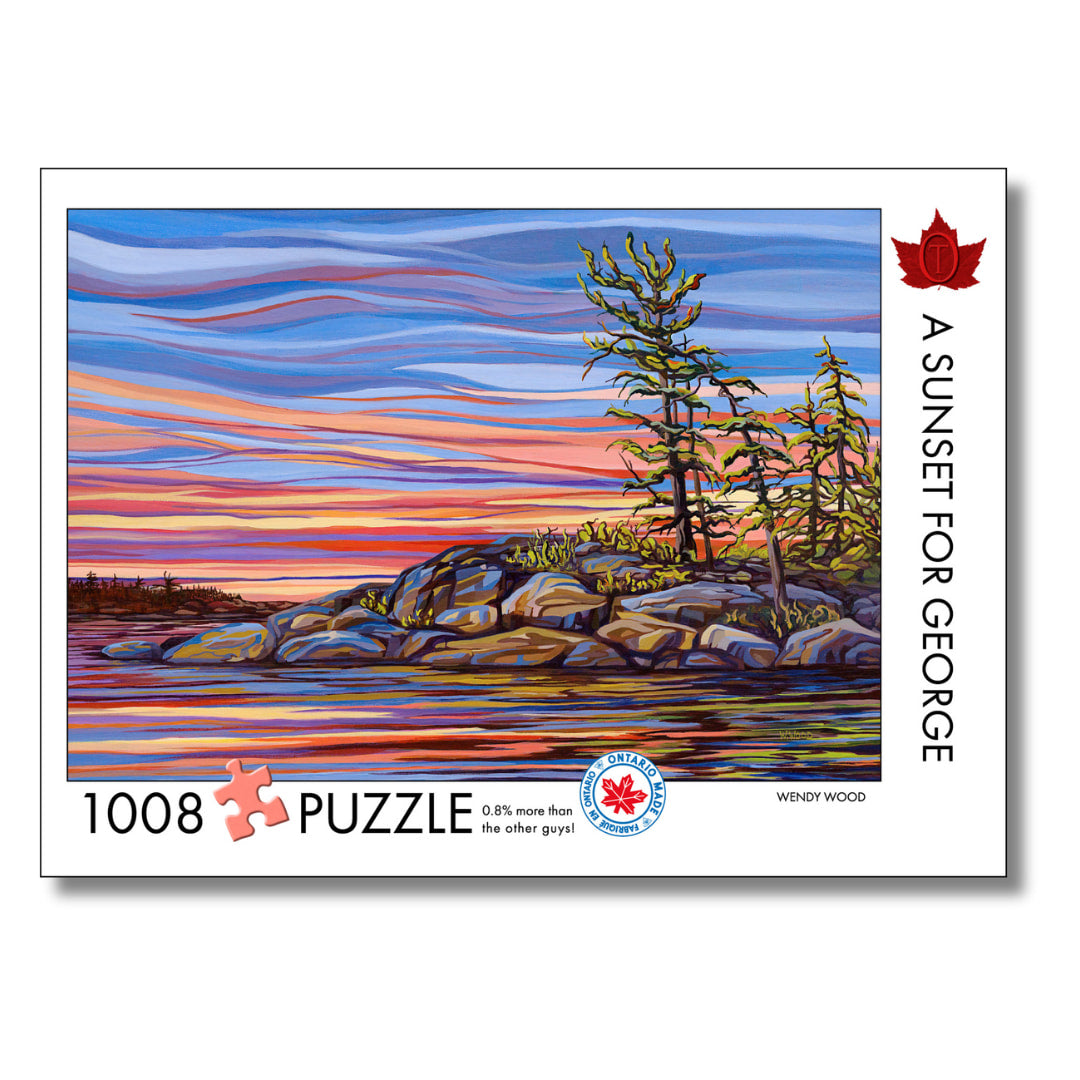 Jigsaw puzzle packaging with a sunset over water and trees design, featuring the artist Wendy Wood.