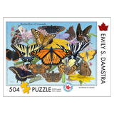 A 504-piece jigsaw puzzle box titled 'Butterflies of Canada' by Emily S. Damstra, featuring a colorful collage of various butterflies and moths on a light blue background with Canadian maple leaf motifs.