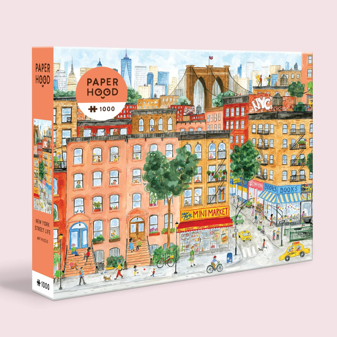 Jigsaw puzzle box with a colorful illustration of a New York street scene, featuring buildings and a mini market.