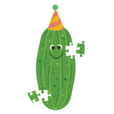 A green cucumber-shaped jigsaw puzzle with a smiling face and a striped party hat, shown on a plain white background with a few loose puzzle pieces nearby.