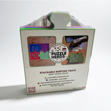 The Puzzle Nerds Stackable Sorting Trays in its retail packaging, featuring a white box with green borders, product images, and a handle cutout at the top, sealed in clear plastic.