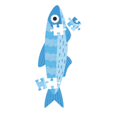 A stylized blue fish made from puzzle pieces, holding one loose puzzle piece near its head, on a plain white background.