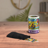 Puzzle canister with colorful design, black bag, and scattered pieces on a wooden surface.