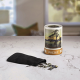 Puzzle canister with a black bag and scattered pieces on a marble surface
