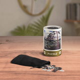 Puzzle packaging with scattered pieces on a wooden surface