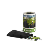 Puzzle packaging with a black drawstring bag and scattered puzzle pieces on a white background