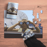 Jigsaw puzzle with a person using binoculars, partially completed on a wooden surface.