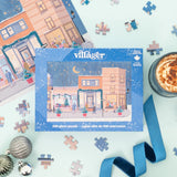 Villager puzzle box with a winter village scene on a light blue background with puzzle pieces and a hot chocolate.