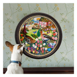 Dog looking at a colorful embroidered scene of a garden with flowers and animals on a wall.
