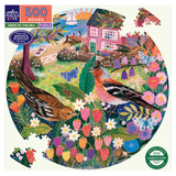 Round puzzle packaging with birds by the sea design featuring two birds, flowers, and a house.