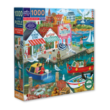 A 1000-piece jigsaw puzzle box by eeBoo, featuring a colorful illustrated harbor scene with boats, seagulls, buildings, and people on a dock. The box includes visible branding and product details on the front and spine.