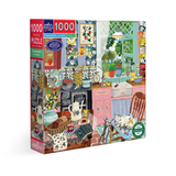 A 1000-piece jigsaw puzzle box titled 'Strawberry Kitchen' by eeBoo Puzzles, featuring a colorful, whimsical illustration of a vintage kitchen with cats, strawberries, flowers, and kitchenware.