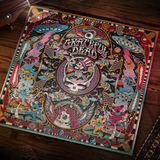 A square Grateful Dead poster or print laid on a dark wooden floor, featuring a highly detailed psychedelic illustration with the Grateful Dead skull-and-flag emblem in the center, flying saucers, stars, and multicolored decorative motifs.