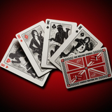 A fan arrangement of five illustrated playing cards on a textured dark red background. The cards feature black-and-white portraits of The Rolling Stones, with one card showing a red and black Union Jack-style design and the text 'THE ROLLING STONES' at the bottom.