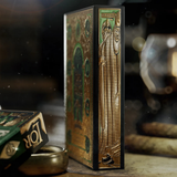 Decorative playing cards with gold and green design on a dark background