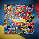 A square illustrated jigsaw puzzle  featuring The Beatles with the band members and the yellow submarine in a dense retro comic design. The artwork is centered on a blue speckled background with a gold textured area in the lower left and part of a red circular object at the right edge.