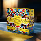 A colorful jigsaw puzzle box of The Beatles Yellow Submarine, photographed on a tabletop with a blurred warm-toned background. The box shows the text 'The Beatles' and has a busy multicolor pattern with yellow, red, blue, black, and white.
